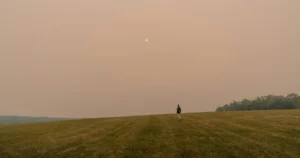 Hazy, orange-tinted sun over a field in Callicoon, New York, during smoky skies caused by Canadian wildfires